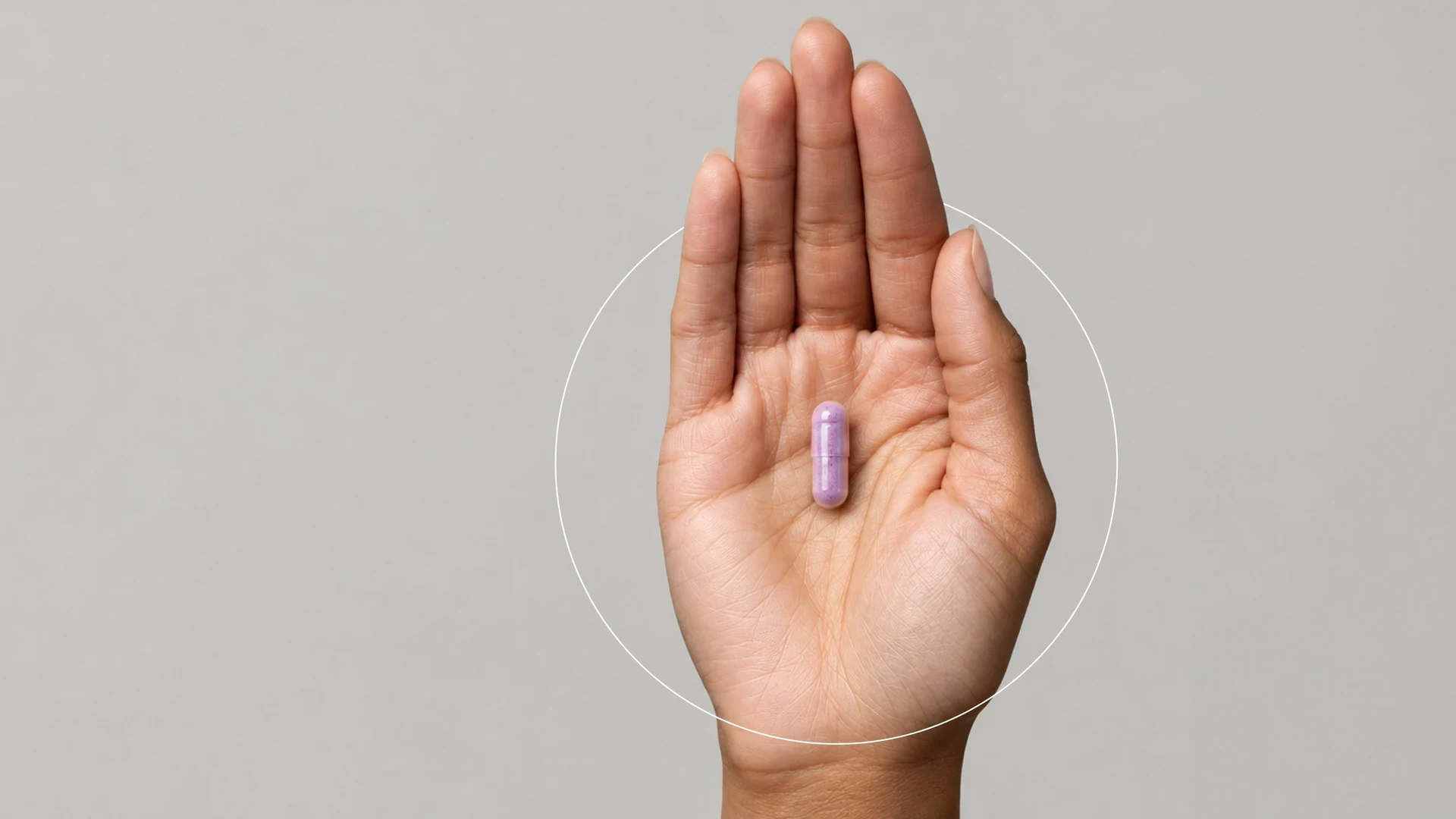 Una cápsula violeta sobre la palma de una mano, campaña de nutricosmética